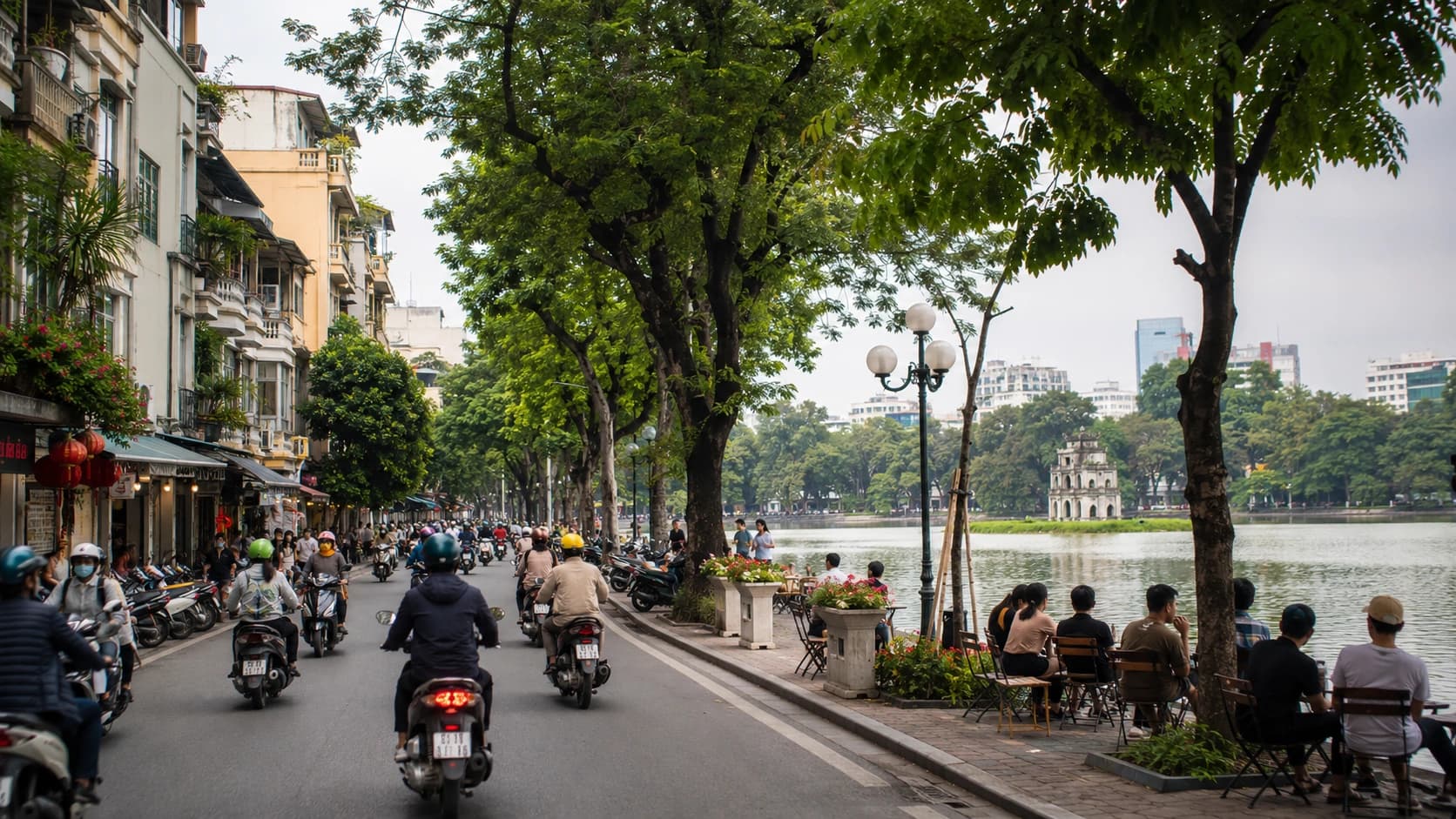 Vue urbaine de Hanoi avec lac, scooters et éléments de préparation pour une installation au Vietnam.